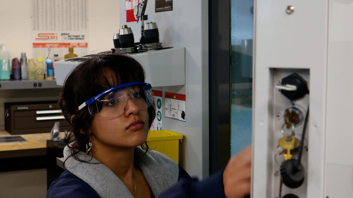 Student working in a physics machine shop